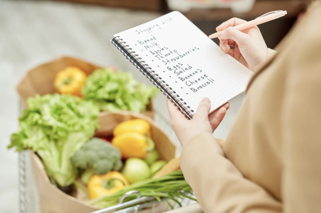 Einkaufsliste für eine blutdrucksenkende Ernährung, dabei Einkaufstüte mit Gemüse