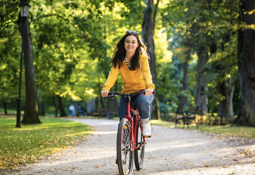 Junge Frau beim Fahrradfahren im Park