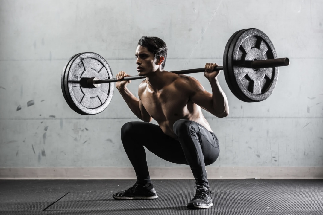 ein junger Mann im Fitnessstudio beim Gewichtheben