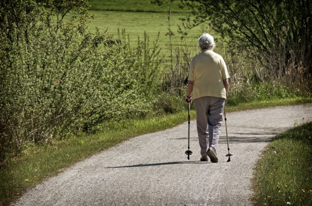 Ältere Frau beim Walken auf Feldweg